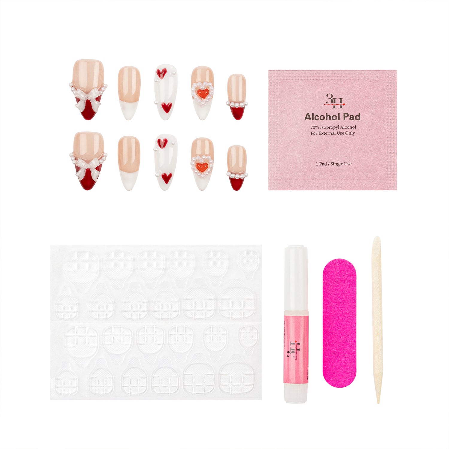 Nail art kit with decorative false nails, a pink alcohol pad packet, adhesive tabs, a pink nail file, a pink nail polish tube, and a wooden cuticle stick on a white background.