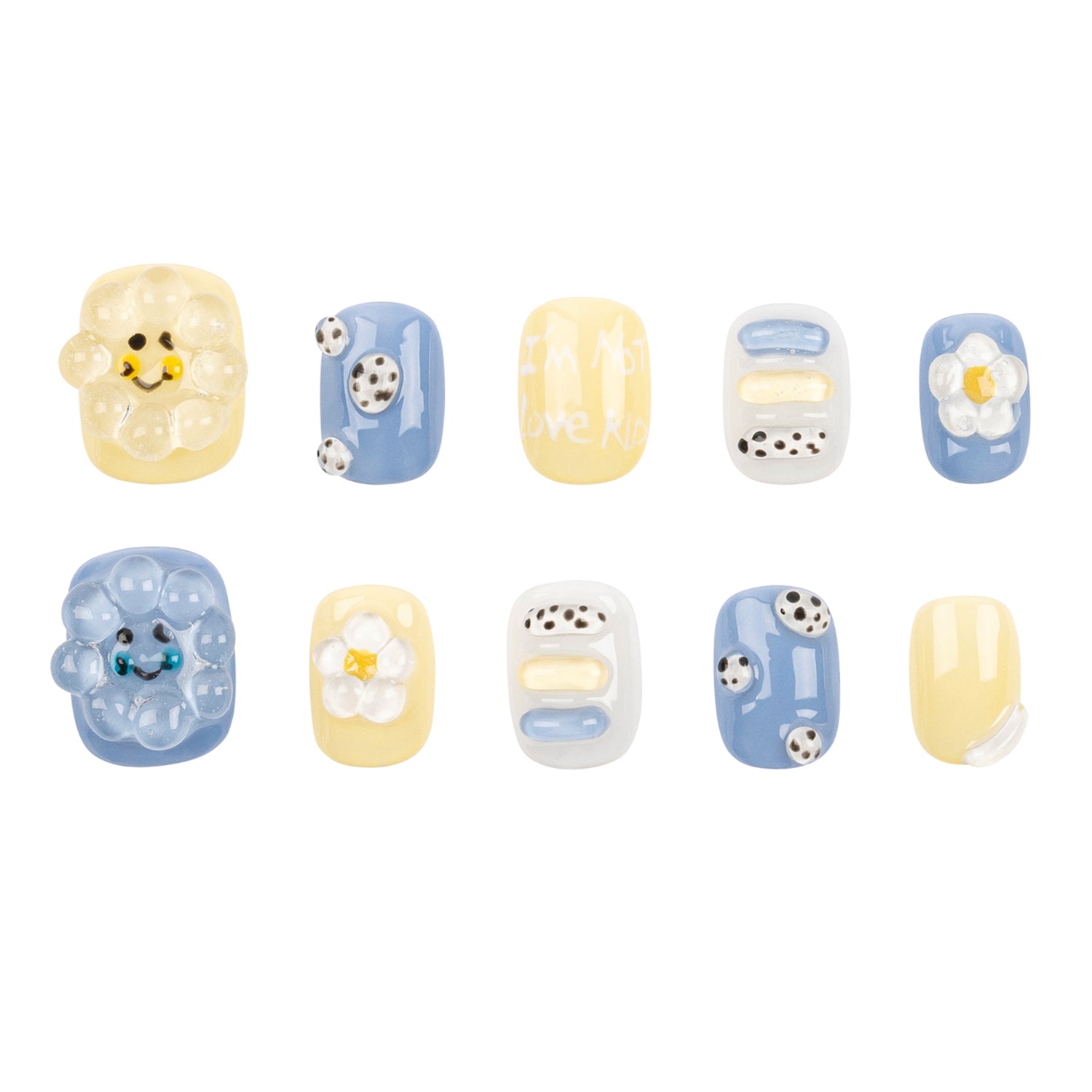 A set of ten decorative press-on nails arranged in two rows on a plain white background. The nails feature pastel yellow, light blue, white, and black designs including smiley faces, flowers, polka dots, and abstract shapes.