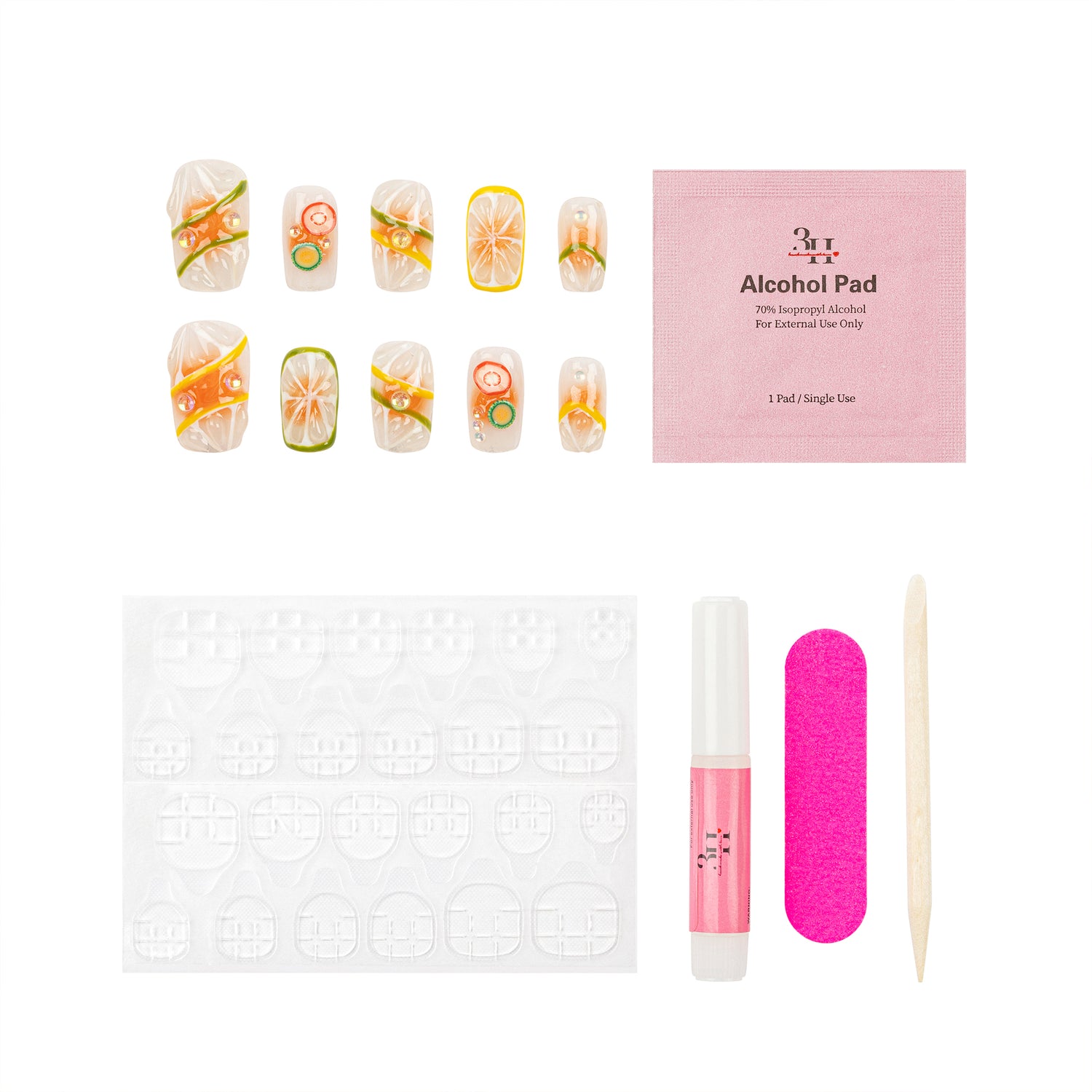 Nail art kit with decorative false nails featuring citrus slice designs, a pink alcohol pad packet, adhesive tabs, a pink nail file, a clear nail polish tube, and a wooden cuticle stick on a white background.