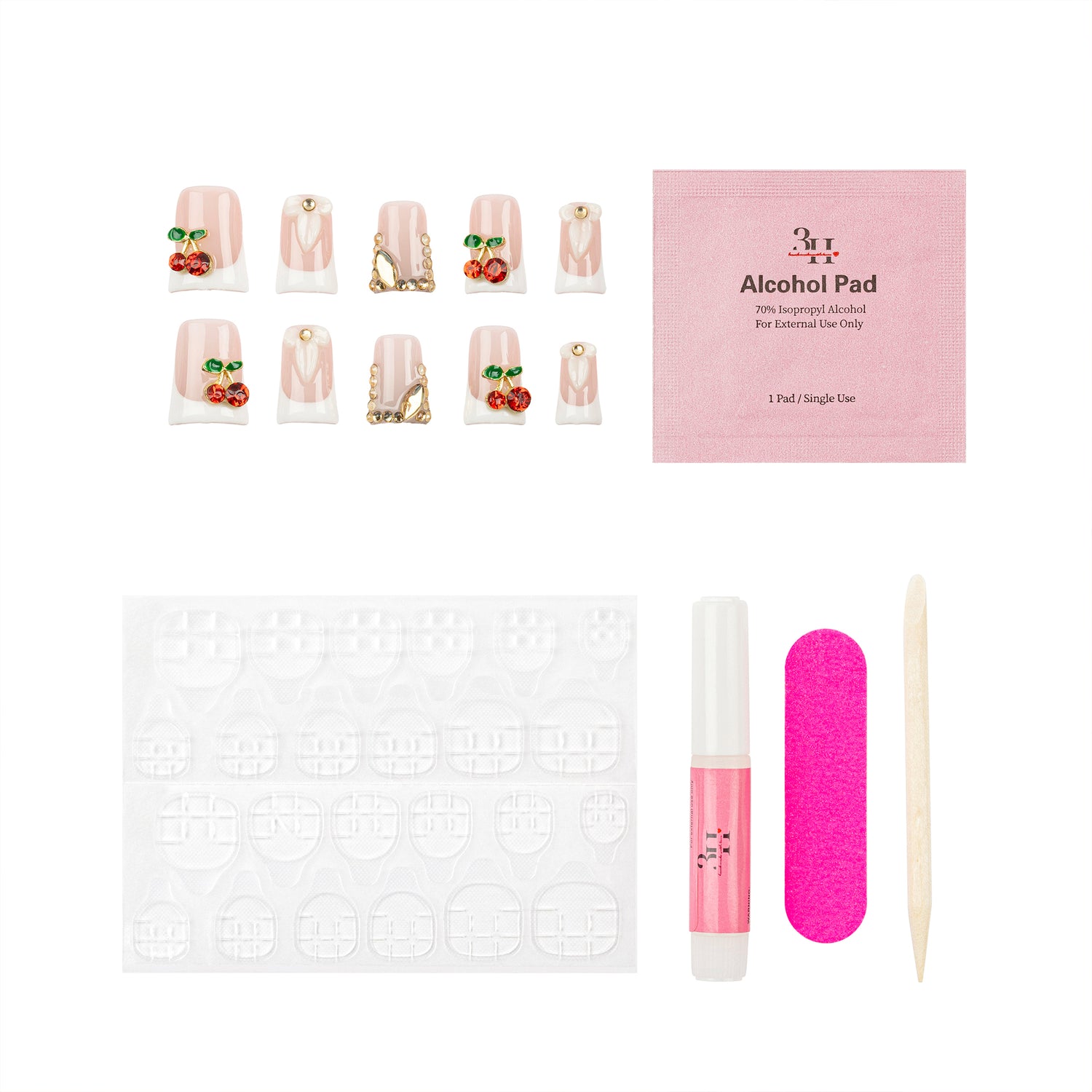 Nail art kit with false nails decorated with pink glitter, gold foil, and cherry designs, a pink packet of gel polish pads, adhesive tabs, a pint nail glue tube, a bright pink nail file, and a wooden stick tool on a white background.