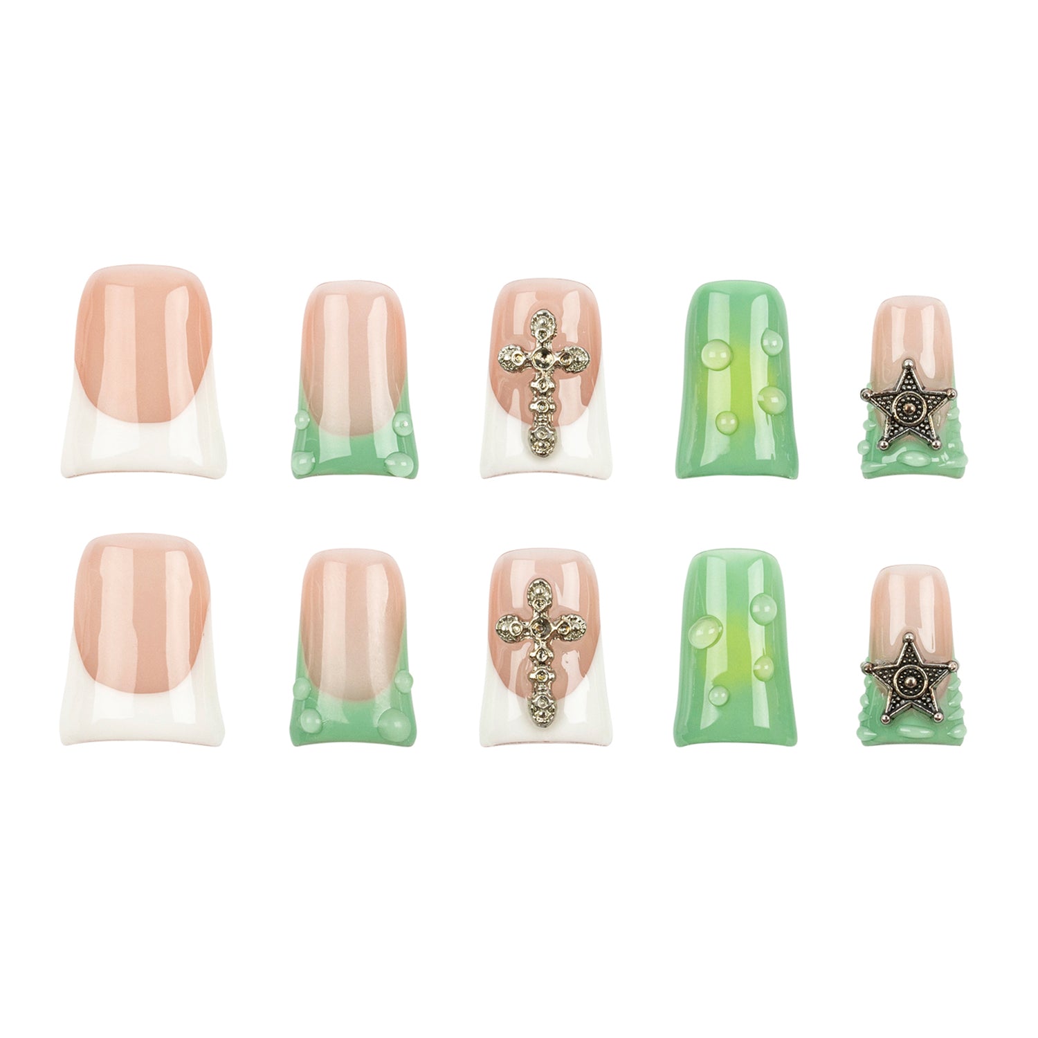 A set of ten press-on nails arranged in two rows of five on a plain white background. The nails feature a glossy peach-pink and white French tip design with various decorative accents, including green gradient tips, rhinestone-embellished crosses, and metallic star charms.