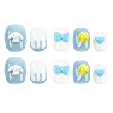 A set of ten decorative press-on nails arranged in two rows on a plain white background. The nails feature light blue and white candy-themed designs, including a Cinnamoroll cartoon character, bows, a lollipop, and a heart.
