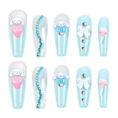 Ten decorative false nails arranged in two rows on a white background. The nails feature a light blue and white striped base with various embellishments including a Cinnamoroll cartoon character, a pink heart, rhinestones, a white bow, and a pink lollipop design.