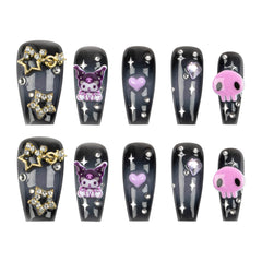 A set of ten coffin-shaped press-on nails arranged in two rows of five on a plain white background. The nails are glossy black with silver glitter stripes, silver rhinestone accents, and various decorative charms including gold stars, a purple Kuromi cartoon character, a purple heart, and a pink skull.