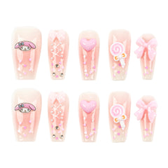 A set of ten coffin-shaped press-on nails arranged in two rows of five on a plain white background. The nails have a pale pink base with various cute decorations including a pink My Melody cartoon character, hearts, bows, and a lollipop motif.