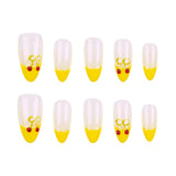 Ten false almond-shaped nails arranged in two rows of five on a plain white background. Each nail has a transparent-to-yellow gradient design with a small yellow bow and two red cherries near the tip.