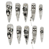 Ten silver glitter stiletto press-on nails with various rhinestone and crystal embellishments, arranged in two rows on a plain white background.