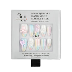 A 10-piece press-on nail kit in its original packaging, featuring pastel iridescent nails with floral and bow designs. The packaging is white with black text and a clear window displaying the nails.