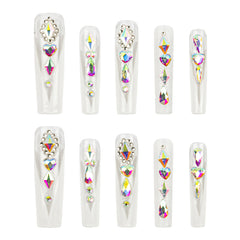 Ten clear press-on nails arranged in two rows of five, each decorated with multiple iridescent rhinestones and crystals in heart, oval, and triangle shapes on a plain white background.