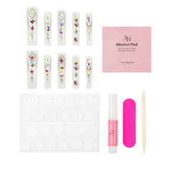 Nail art kit with ten decorated false nails, a pink alcohol pad, a pink nail glue tube, a bright pink nail file, and a cuticle stick on a white background.