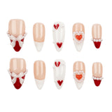 A set of ten false press-on nails arranged in two rows on a plain white background. The nails feature a mix of nude beige, white, red, and pearl embellishments, including heart and bow designs.