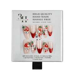 A 10-piece reusable press-on nail kit with red and white strawberry-themed designs, presented in its original white packaging box with black text.