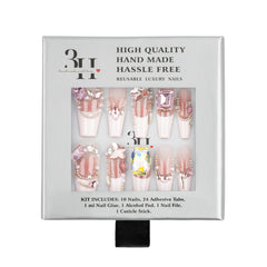 A boxed set of decorative press-on nails in a white package with a clear window showing ten long coffin-shaped nails in pink, nude, and embellished designs. 