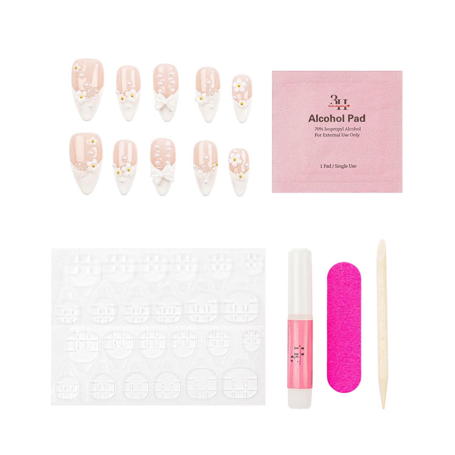 Nail art kit with decorative false nails, a pink packet of alcohol pads, adhesive tabs, a pink nail file, a pink nail polish tube, and a wooden cuticle stick on a white background.