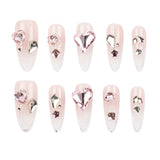 Ten press-on nails with a pale pink and white ombre gradient, embellished with various pink and silver rhinestones, displayed on a clean white background.