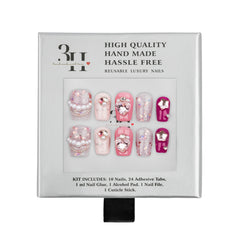 A 3H brand reusable press-on nail kit in its original packaging, featuring 10 decorative pink and white nails with pearl and rhinestone details, 24 adhesive tabs, nail glue, an alcohol pad, a nail file, and a cuticle stick.