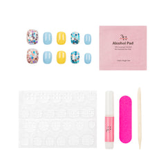 Nail art kit on a white background, including false nails with blue, yellow, and multicolor glitter designs, a pink single-use alcohol pad, adhesive tabs, a pink nail file, a nail polish tube, and a wooden stick.