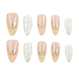 Ten press-on nails arranged in two rows on a plain white background. The nails feature a glossy nude-peach to pale yellow gradient with silver metallic starburst accents and pearl-like bead details, alongside white textured and pearl designs.