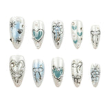 Ten silver-tone almond-shaped press-on nails with light blue and white designs, including hearts, bows, stars, and pearl accents, arranged in two rows on a white background.