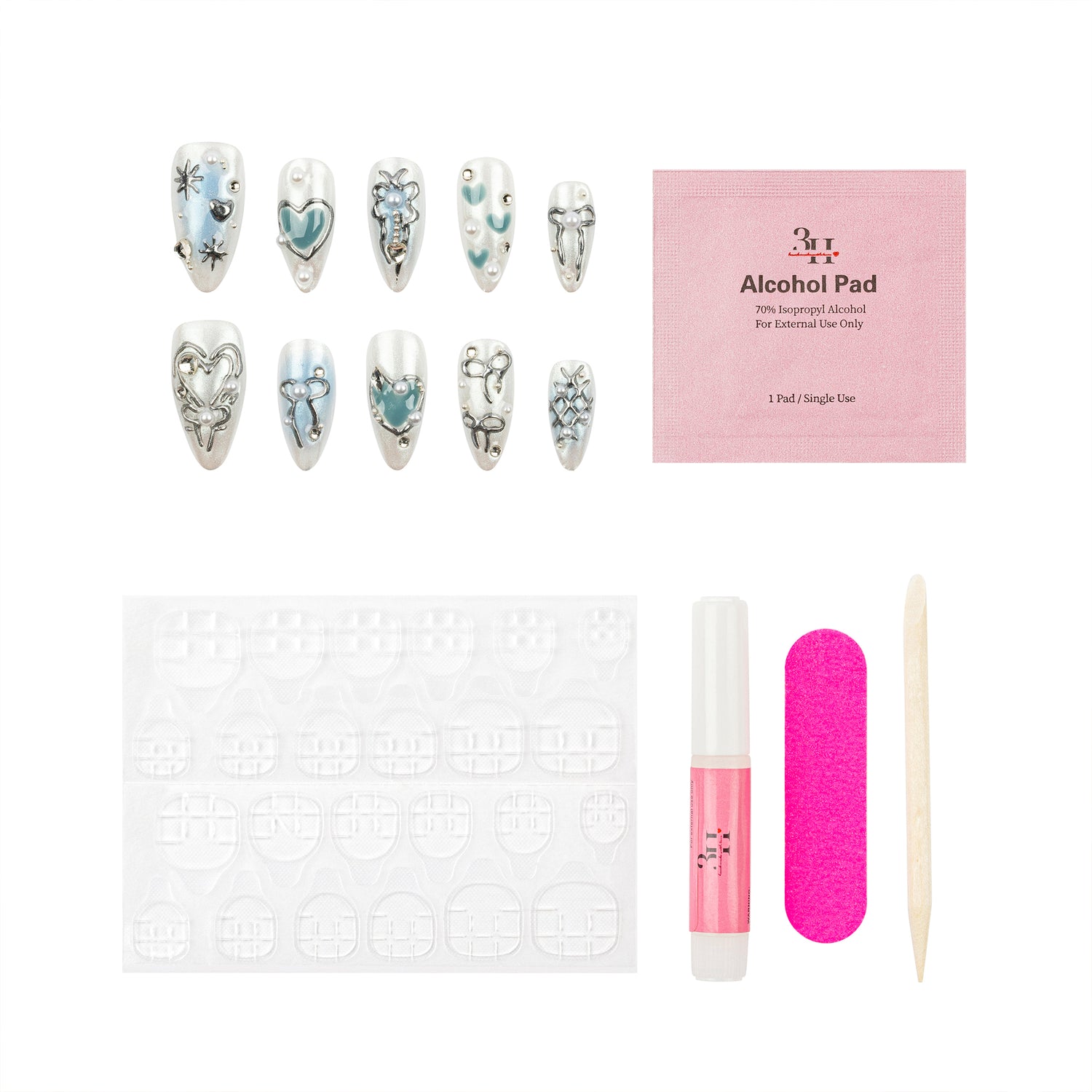Nail art kit with decorative nail tips, a pink alcohol pad packet, adhesive tabs, a pink nail file, a pink nail polish tube, and a wooden cuticle stick on a white background.