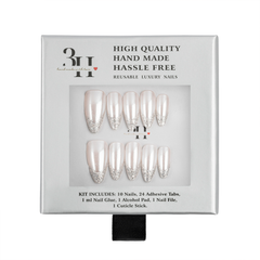 A 10-piece press-on nail kit in its original packaging, featuring glossy white almond-shaped nails with silver glitter tips. The packaging is gray with black text and a clear window displaying the nails.