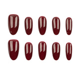 Ten glossy dark red press-on nails arranged in two rows on a plain white background.