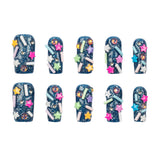 Ten false nail tips decorated with a dark blue glitter base and colorful star, sprinkle, and rhinestone embellishments, arranged in two rows on a white background.