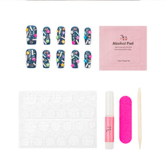 Nail art kit on a white background, featuring 10 decorated false nails with nail art designs, a pink packet labeled '3E JET Alcohol Pad', adhesive tabs, a pink glue nail tube, a pink nail file, and a wooden cuticle stick.