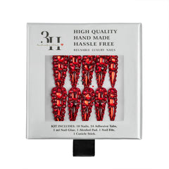 A boxed set of red rhinestone-embellished reusable luxury nails, shown in its white retail packaging with text describing the kit contents and quality.