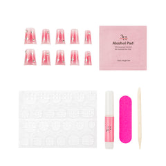A nail art kit laid out on a white background, including pink gradient false nails with rhinestones, a pink alcohol pad packet, a white nail file, a pink nail glue tube, a wooden cuticle stick, and adhesive tabs.