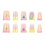 Ten false press-on nails arranged in two rows of five on a plain white background. The nails have a glossy pink base with pastel yellow, purple, and blue gradient accents, plus decorative star and swirl embellishments.