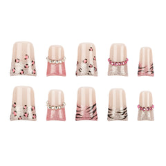 Ten false press-on nails arranged in two rows of five on a plain white background. The nails feature a glossy nude-pink base with glittery pink sections, leopard print spots, zebra stripes, and small pearl-like bead accents.
