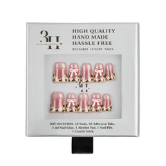 A boxed set of reusable press-on nails on a white background. The package is white with black text and a clear window showing two rows of decorative nails with pink tanslucent grandients, pale pink bows, and leopard-print tips.