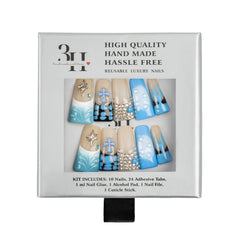 A boxed set of reusable luxury nail art pieces on a white background. The package shows a window with six decorative nails in beige and light blue designs with rhinestone-like embellishments, plus text reading 'HIGH QUALITY HAND MADE HASSLE FREE' and 'REUSABLE LUXURY NAILS.