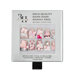 A boxed set of decorative reusable luxury press-on nails. The square package is light gray with a clear window showing ten pink and white nail designs with bows, hearts, stripes, and small embellishments.