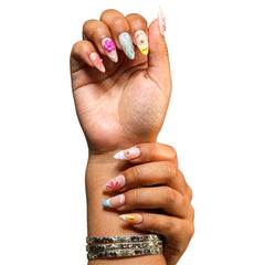 Miami medium almond press-on nails by 3H Nails, featuring a nude base with pink florals, bright yellow and aqua French tips, and metallic accents, shown in a lifestyle image.