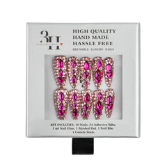 A 10-piece set of reusable press-on nails in a silver-gray retail box. The nails feature a metallic rose gold base adorned with large, faceted hot pink rhinestones.