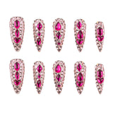 Ten stiletto-shaped false nails with bright pink gemstones and silver rhinestone borders, arranged in two rows of five on a white background.