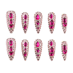 Ten stiletto-shaped false nails with bright pink gemstones and silver rhinestone borders, arranged in two rows of five on a white background.