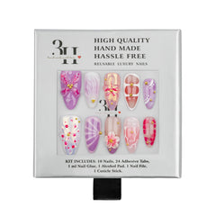A 3H brand hand-made luxury nail kit in its original packaging, featuring 10 reusable press-on nails in pink, purple, and white designs with gold bead accents, along with adhesive tabs, nail glue, an alcohol pad, a nail file, and a cuticle stick.