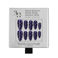 Nail extension kit with navy blue nails with white polka dots in a silver box.