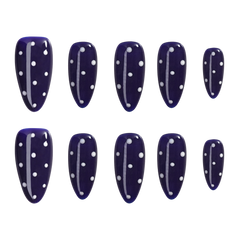A set of ten dark navy blue press-on nails with white polka dots and white vertical accent lines, arranged in two rows of five on a plain white background.
