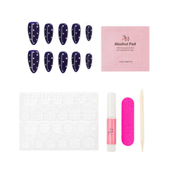 Set of polka dot nail press-ons, alcohol pad, adhesive tabs, pink nail file, and wooden stick on a white background.