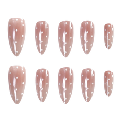 Ten almond-shaped press-on nails arranged in two rows of five on a plain white background. The nails have a glossy dusty pink base with small white polka dots.