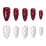 Ten artificial press-on nails arranged in two rows of five on a plain white background. The top row consists of glossy deep red almond-shaped nails with white polka dots, and the bottom row consists of glossy white almond-shaped nails with small red polka dots.