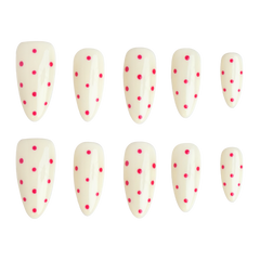 Ten false press-on nails arranged in two rows of five on a plain white background. The nails are glossy off-white with small bright pink polka dots scattered across the surface.