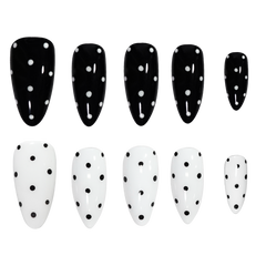Ten artificial press-on nails arranged in two rows on a plain white background. The top row consists of five glossy black nails with white polka dots, and the bottom row consists of five glossy white nails with black polka dots.