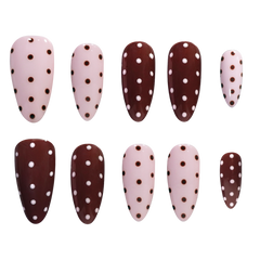 A set of ten false press-on nails arranged in two rows on a plain white background. The nails have an almond shape and are decorated with a polka dot pattern in brown and pink, with alternating light pink and dark brown nails.