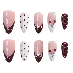 Ten almond-shaped press-on nails arranged in two rows of five on a plain white background. The nails feature various designs: pink-to-white gradient with dark burgundy tips, white with burgundy dots, white with a white bow motif, pink-to-white gradient with cherry details, and dark burgundy with white dots.