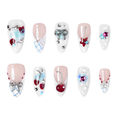 Chicago medium almond press-on nails by 3H Nails, featuring nude and white tones with blue accents, silver bows, stars, cherries, and rhinestones.